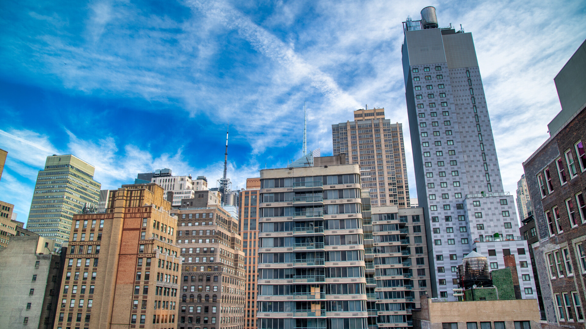 Modern and old buildings and skyscrapers of Midtown Manhattan under a blue sky, New York City - NY - USA